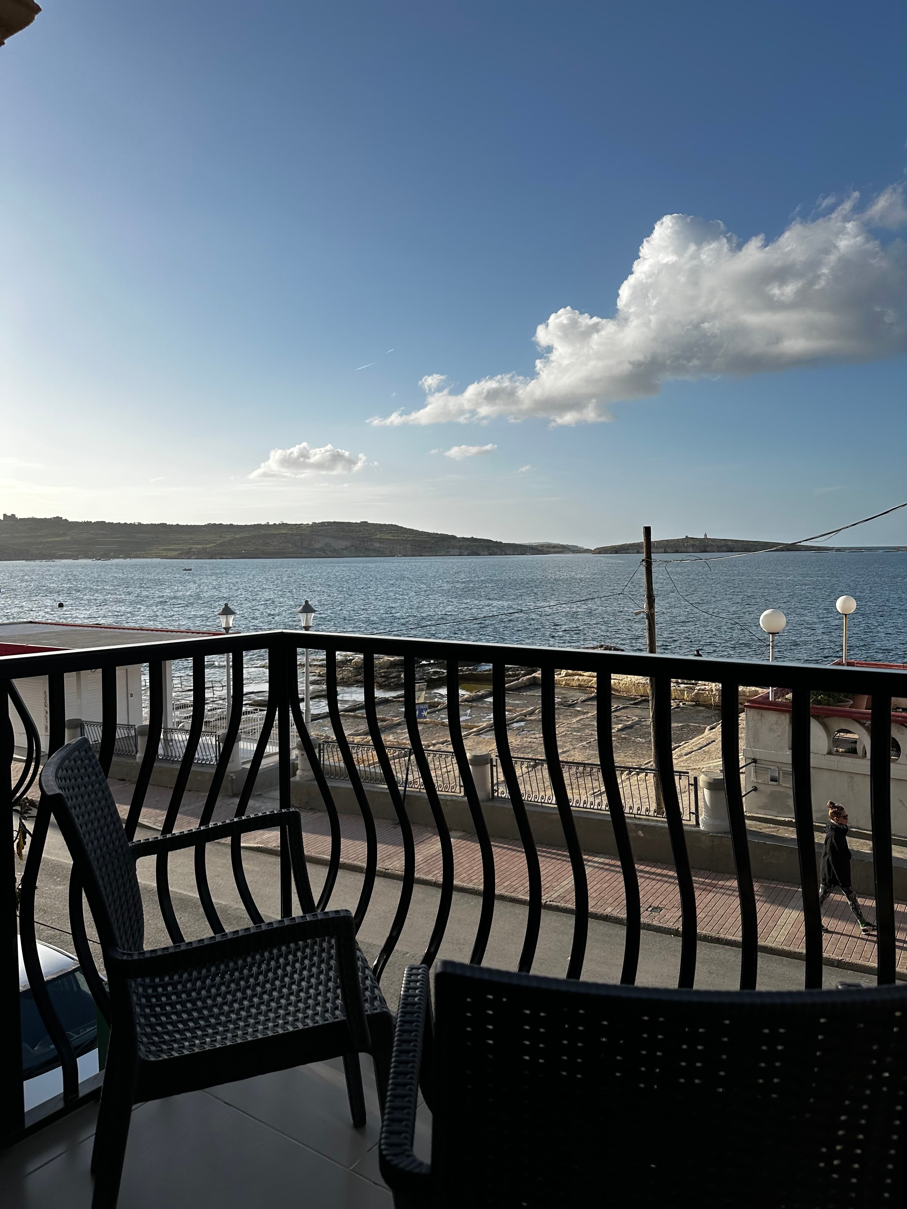 Balcony seating looking out over the water at sunset
